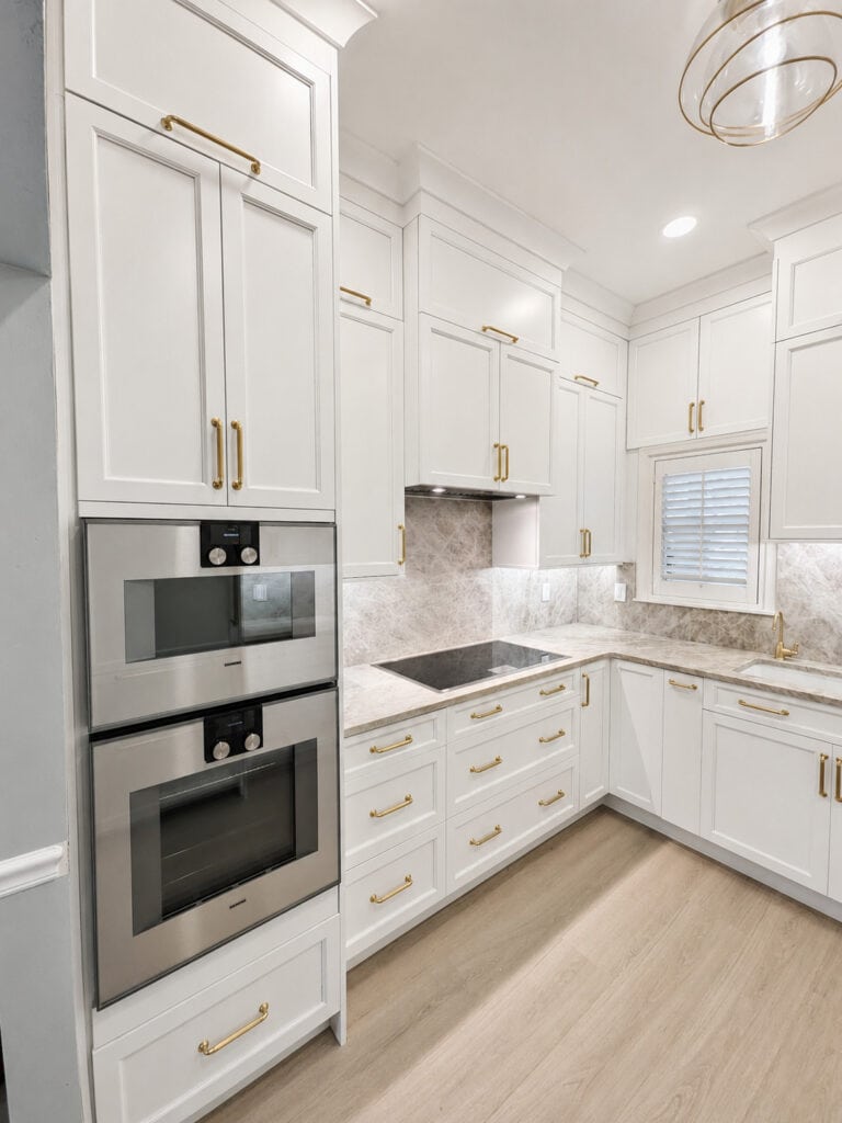 Boca Raton kitchen remodel with stainless double wall ovens, induction cooktop, and Taj Mahal quartzite counters.