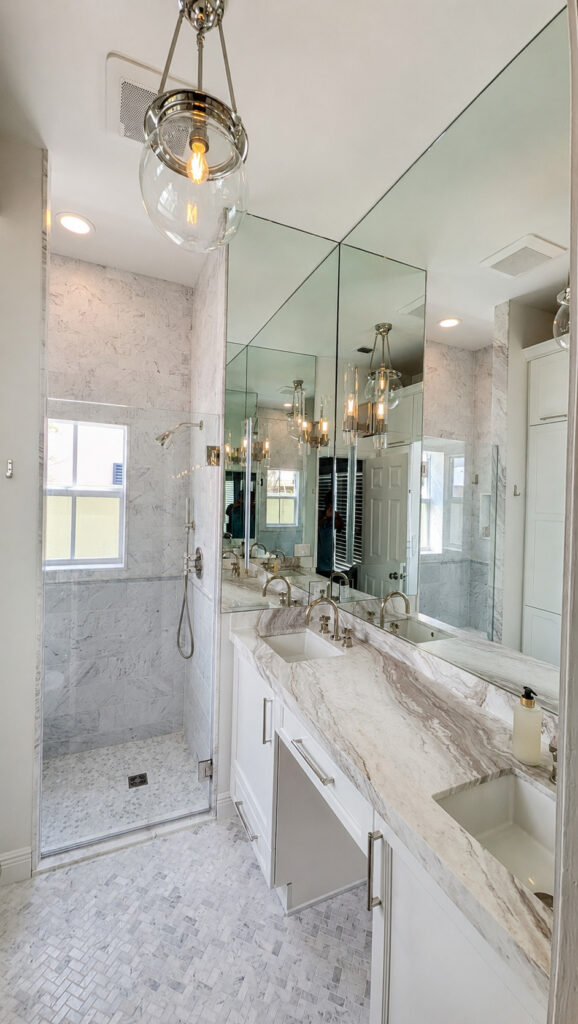 Boca Raton bathroom remodel showing a quartzite double vanity with polished nickel faucets beside a marble walk-in shower.