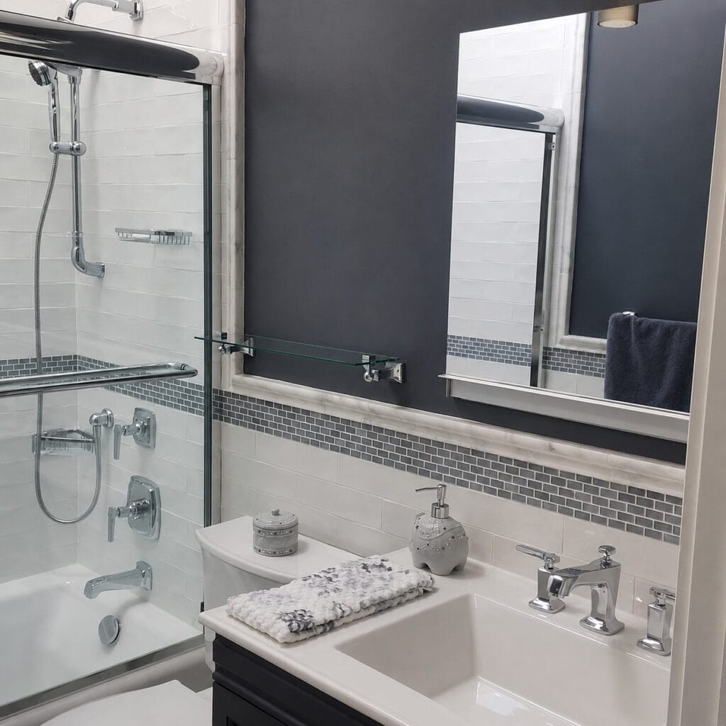Transitional bathroom with a tub and shower, white subway tile, a grey glass mosaic accent, a dark vanity, and chrome fixtures.