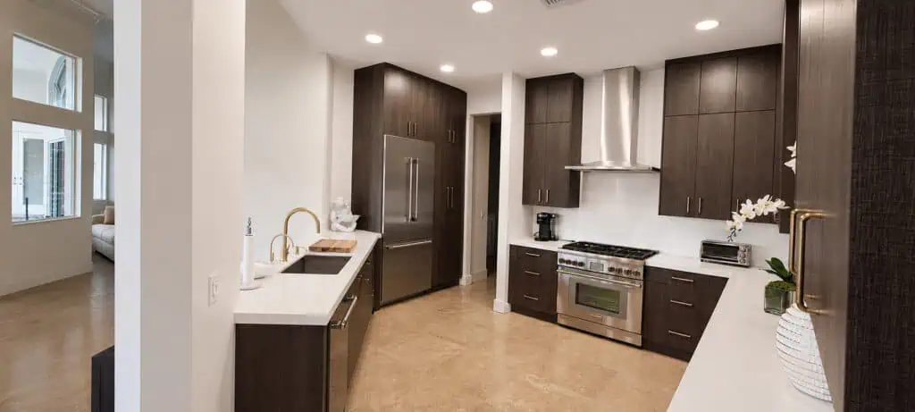 West Palm Beach Ibis kitchen with dark wood cabinets, a stainless range and hood, a French-door refrigerator, and white quartz counters.