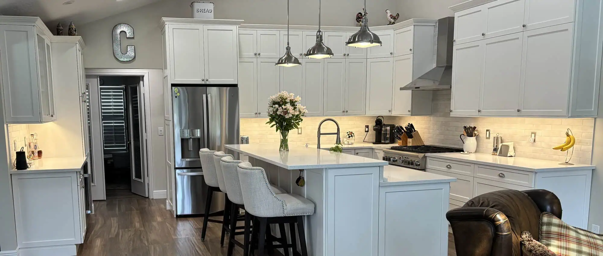 Palm Beach Gardens PGA kitchen remodel with white cabinets, quartz countertops and a seated island under pendant lighting