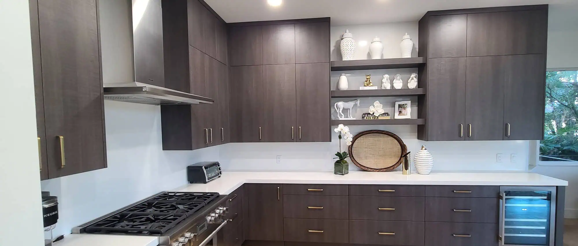 West Palm Beach Ibis kitchen remodel with dark wood-grain flat-panel cabinets, brass bar pulls and white countertops